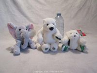Front view of three plush toys: elephant, polar bear, smaller polar bear ornament with water bottle for scale