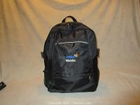 Front view of black backpack with stitched MSN Mobile logo and three front zipped pockets.