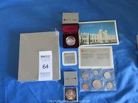 Complete lot shown with all coin sets and coins displayed on blue cloth background.