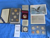 All items in lot displayed on blue cloth: uncirculated and specimen coin sets, proof and brilliant uncirculated silver dollars, coin cases, and certificate cards.