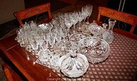Wide view of full lot on table showing goblets, tumblers, bowls and covered dishes