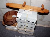 Wooden collector plate holder sitting behind stacked boxes containing plastic plate frames.