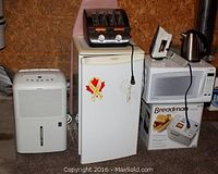 Front view of all appliances including dehumidifier, mini fridge, toaster, microwave box