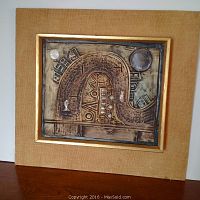 Full view of the framed square ceramic tile with abstract map design and textured fabric mat frame.