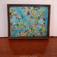Front view of the enamel tile showing colorful birds and flowers with blue background in brass frame.