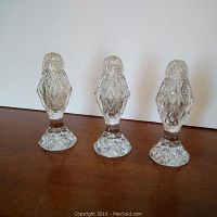 Three smaller lead crystal salt and pepper shakers with intricate diamond-cut pattern and original lids, clear and in excellent condition.