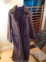 Full front view of long ladies suede winter coat on a dress form, showing medium chocolate brown color, fur collar, and large front pockets.