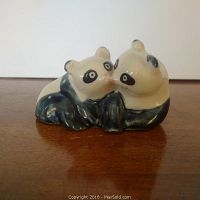 Pair of blue and white porcelain panda bears positioned together on a wooden surface, shown from the front angle.
