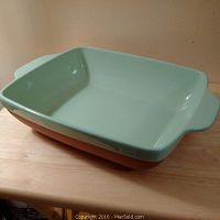 Large rectangular terracotta casserole dish with mint green glazed interior and handles shown from an angle.