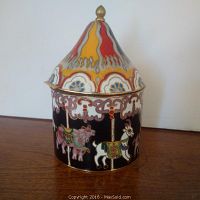 Full view of cloisonne carousel box showing detailed enamel carousel animals and flame patterned lid with gold finial.