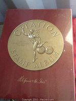 Front cover of the red Citation Stamp Album showing gold embossed stamp and lettering.