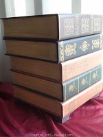 Close up of faux book spines showing decorative gilded patterns and faux aged book look