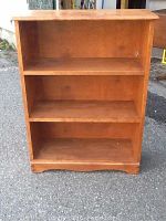 Front view of the three-shelf maple bookcase showing shelves and wood finish.