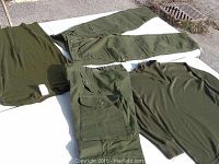 Photo showing all four items laid out: two pairs of cargo pants, one short-sleeve shirt and one long-sleeve undershirt, all in olive green.