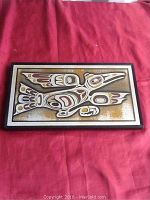 Front of etched aluminum plaque showing Raven and child design.