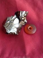 Photo of crystal shungite and a Baltic amber donut bead on red fabric background