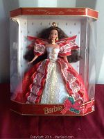 Front view of the Special Edition Happy Holidays Barbie doll in original packaging showing the doll in a red, white, and gold festive gown with a crown and holiday box design.