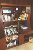 Full view of books arranged on shelves of a bookcase showing a large collection including various subjects and genres.