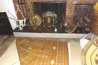 Fireplace tools with brass tools and stand in front of fireplace, cotton rug folded beside