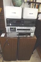 Full stack of components and speakers: two Bose Roommate speakers on top, Sony and Akai units in middle, wood veneer Advent speakers at bottom.
