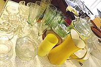 Yellow Dansk pan with two handles, assorted clear glassware including bowls, ice cups, and stemware