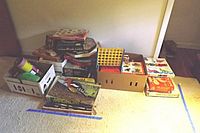Photo showing several boxed board games and puzzles arranged on carpet including Careers, Spirograph, Chess, Parcheesi, Magnavox game, and a Connect Four style game.