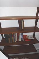 Four brown wooden wall mount shelves against a white wall, showing the overall form and size of the shelves.