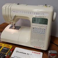 Front view of Singer Quantum XL-1 sewing machine on table, accessory compartment closed