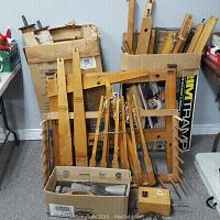 Full view of wooden loom parts stacked in cardboard boxes including frame pieces and beams.