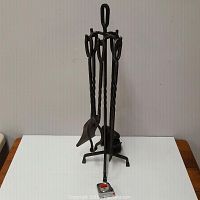 Full view of the wrought iron fireplace tool set on stand with a tape measure showing scale