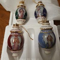 Four heirloom porcelain Bradford Edition Christmas ball ornaments with angel designs in original foam packaging.