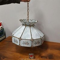 Full view of hanging lamp shade held by chain, showing overall shape and pattern.
