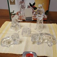 Overview photo showing all five glass nativity scene figurines arranged on a yellow towel with a box behind them