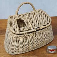 Front side view of the vintage fishing creel showing its shape, weaving pattern, and handle with a small measuring tape to show scale.