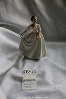 Full view of the Royal Doulton Donna figurine showing the entire piece posed against a white cloth background.
