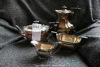 Full set of four Sheffield plate tea service items displayed on dark fabric, showing overall condition and design.