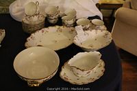 Overview of platter, bowls, sauce boat, cups and saucers arranged on table