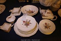 Full view of Mason's Firestone china pieces including plates, bowls, cream, sugar, sauce boat and teapot arranged on table.