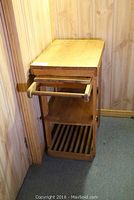 Full view of wooden kitchen cart showing pull-out tray, shelves and handle