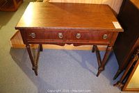 Front view of solid wood desk showing tabletop, drawers and legs