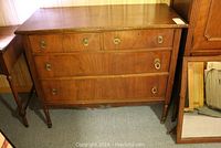 Full view of wooden dresser with mirror leaning beside