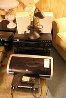 Stereo components with white speakers and black desk lamp on top, HP printer in front