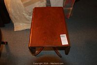 Photo of the drop leaf table fully closed showing rectangular top, wood finish and overall shape.