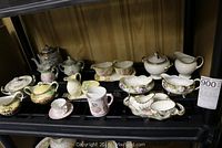 Wide view on shelf showing multiple cream and sugar sets with various designs and colors.