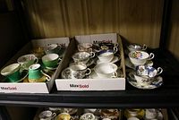 Three boxes containing 15 assorted tea cups and saucers.