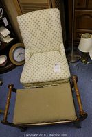 Photo showing the ladies upholstered chair with skirt and patterned upholstery alongside the footstool with beige padded top and wooden frame, arranged on carpeted floor.