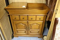 Front view of the solid maple dry sink cabinet showing drawers, double doors, and wood finish.