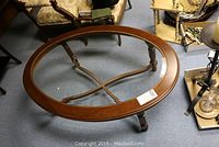Top perspective of the oval coffee table showing wooden frame and bevelled glass top with reeded legs.