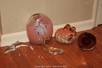Overview of the glass art collection including two dolphins, blown glass vase, pumpkin, and paperweight