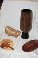 Group photo showing all items: wooden bowl, bull sculpture, Cuban wood trivet, and striped wooden vase